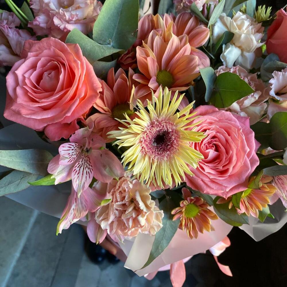 Букет из альстромерий, роз, гвоздики, эустомы, кустовой хризантемы и герберы в стильной шляпной коробке